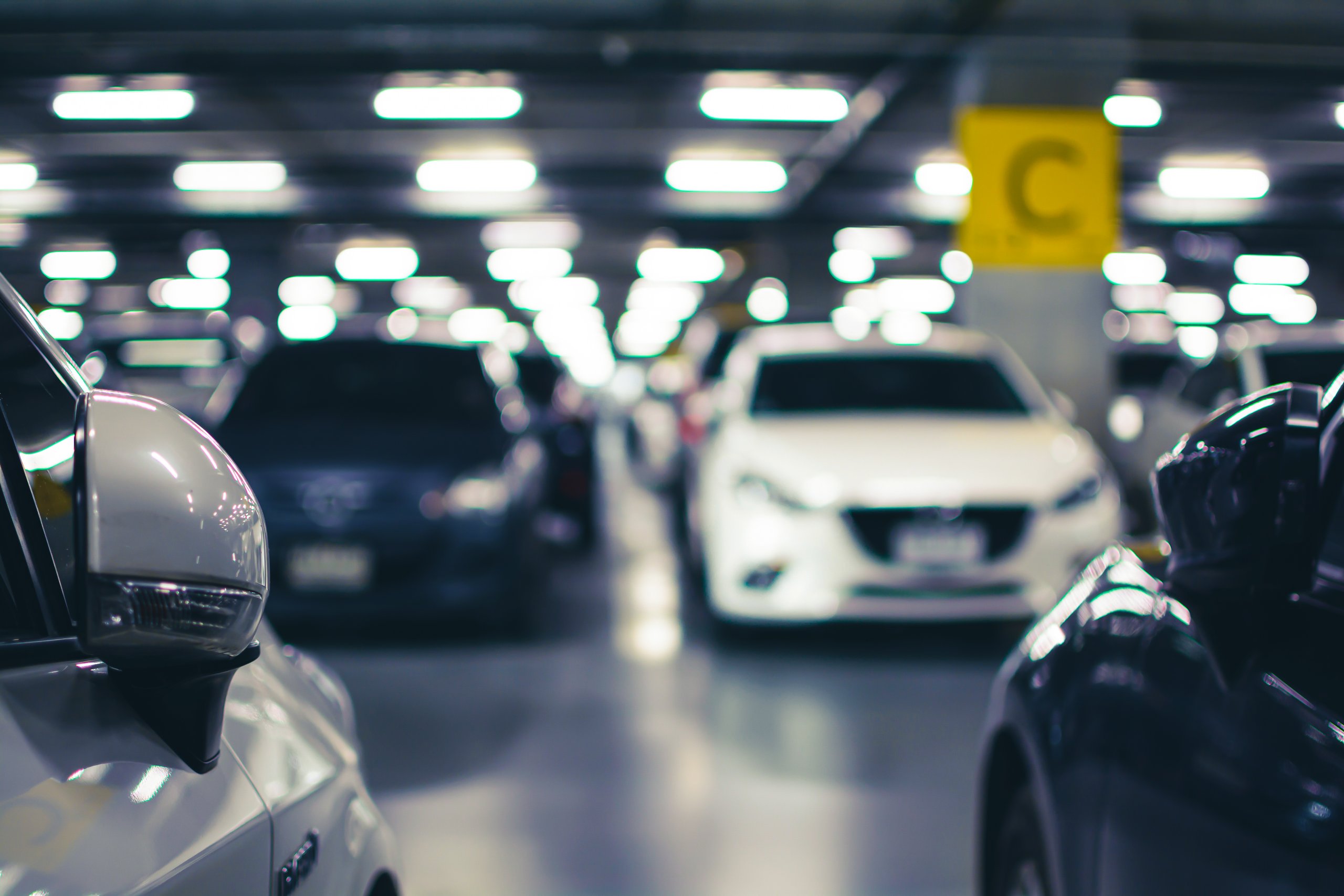 Moderne og veloplyst parkeringsplads med parkerede biler.